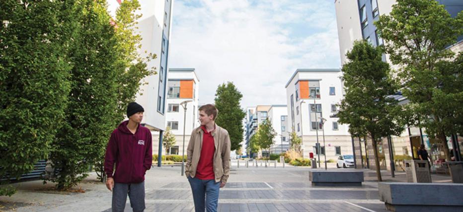 Two students walking through Pier Quays