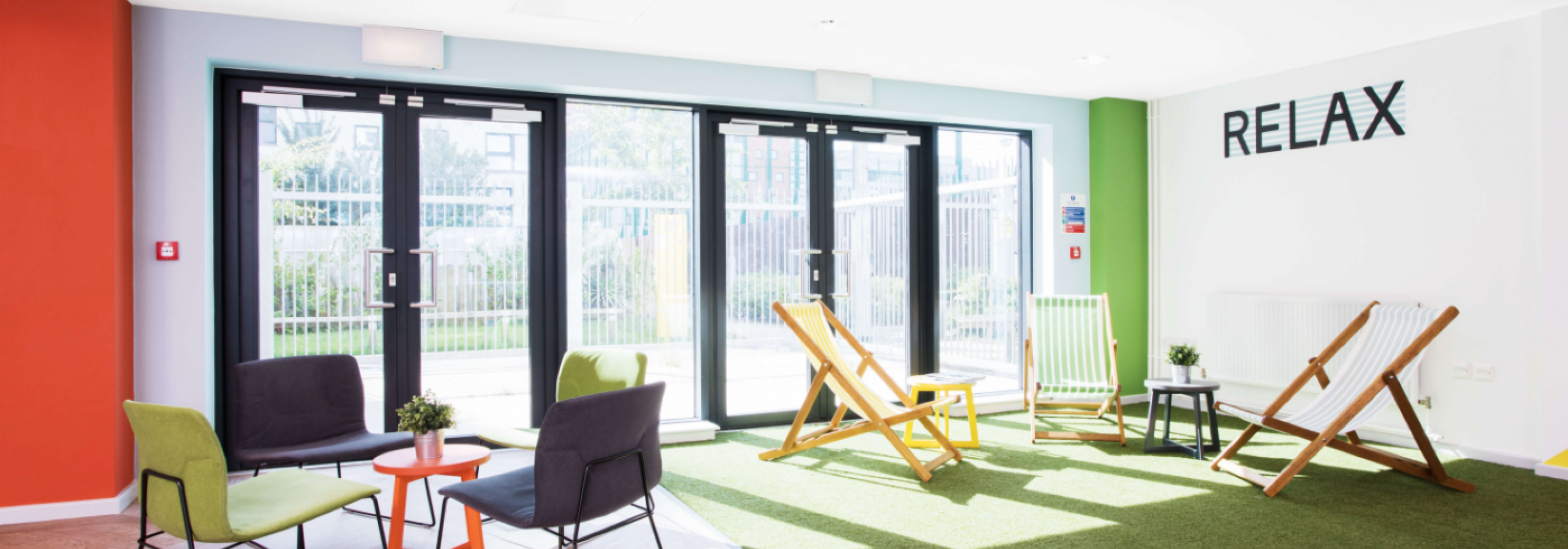 Common room, glass doors, artificial grass, chairs, table