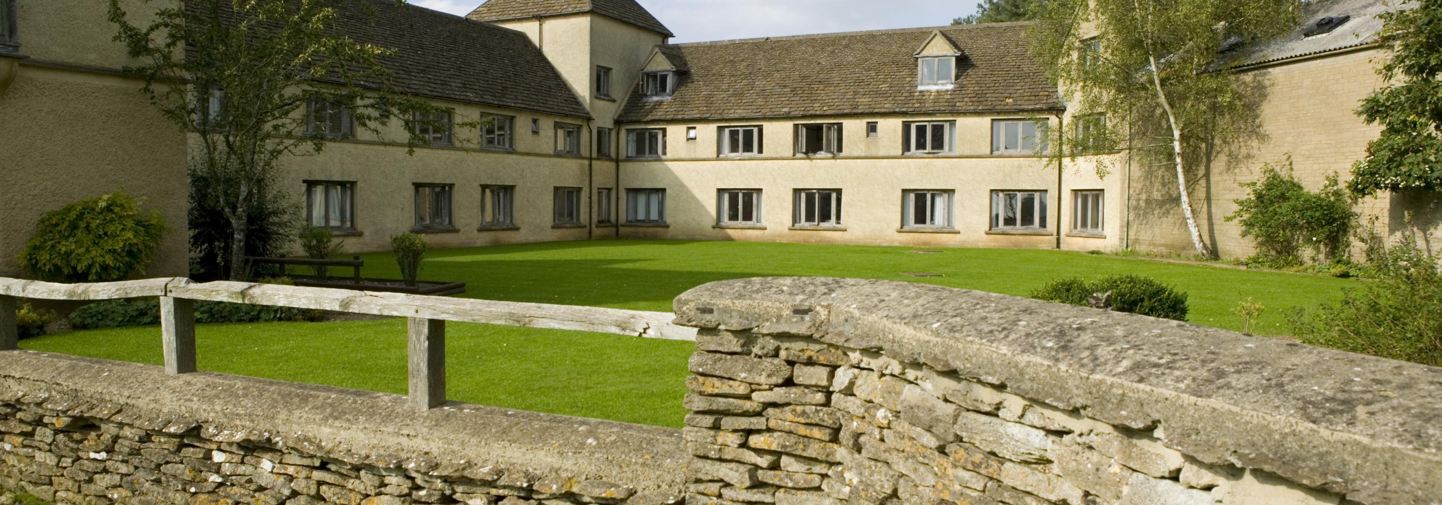 Exterior of buildings, with grassed area and a stone wall