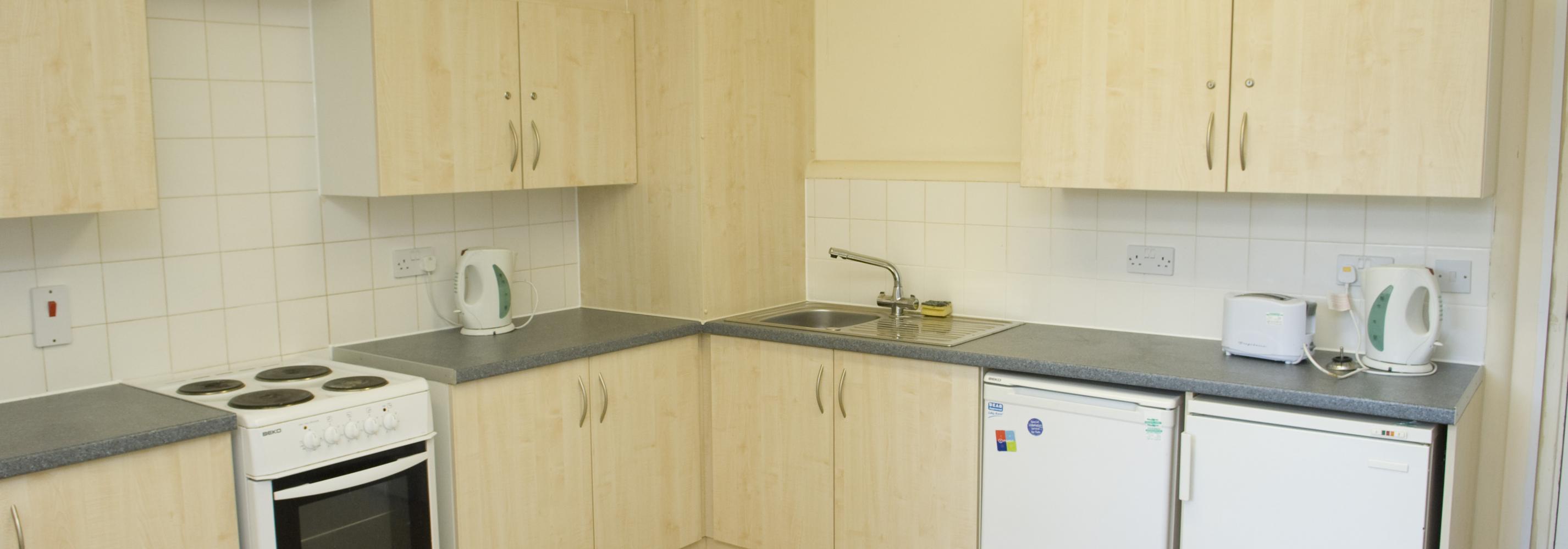 Kitchen with oven, hob and sink and fridge freezers