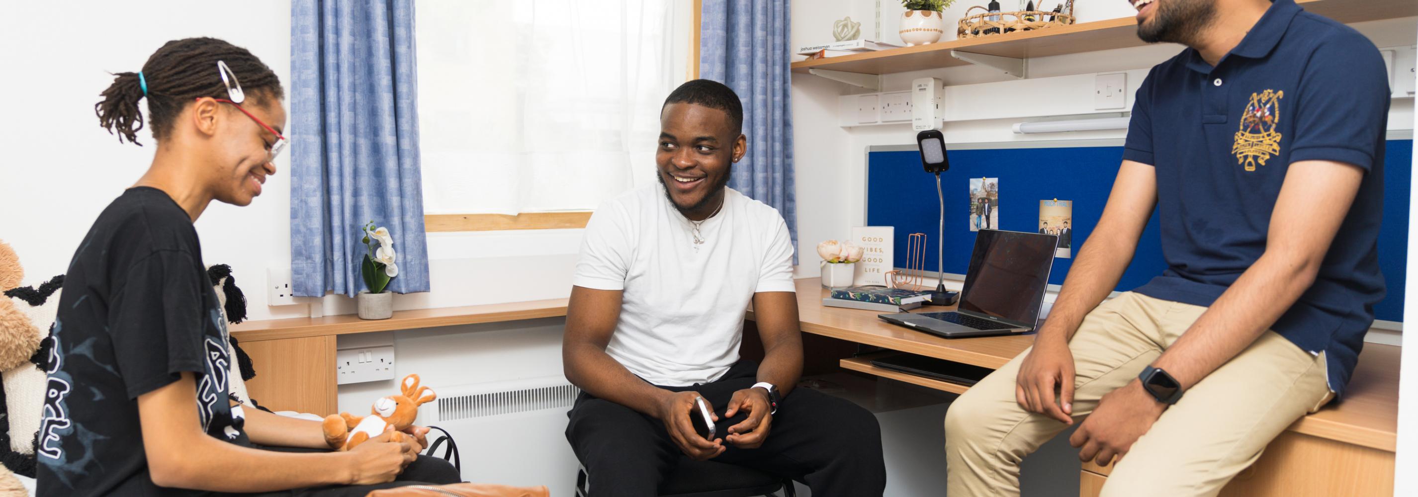 Students chatting in a bedroom on de Havilland campus