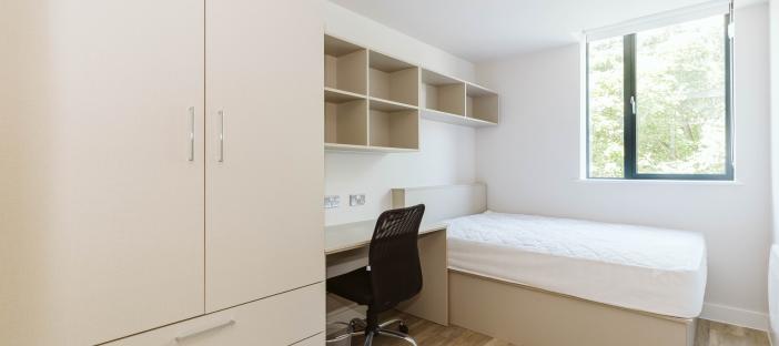 Bed, desk with chair and wardrobe
